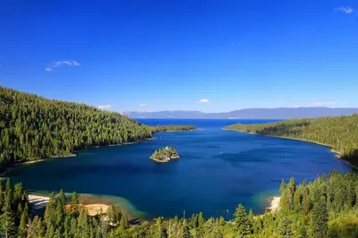 an island in a lake in the middle of a forest at West Shore Haven - Near Beach & Outdoor Fun in Tahoma