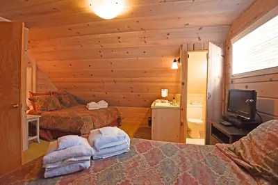 a room with two beds and a television in a cabin at Woodland Chalet - 2 miles from Beach Access in Tahoma