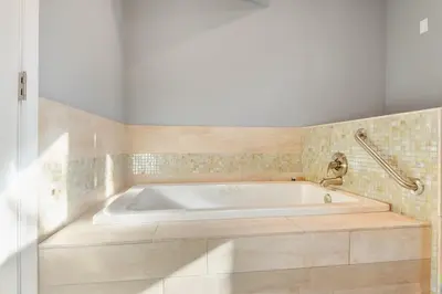 a white bath tub in a bathroom with tiles at Alpine Chalet Nature Lovers Rejoice Chic 4 BDR in Alpine Meadows