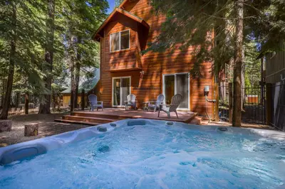 a log home with a hot tub in the yard at Alpine Gem Near Homewood Mountain in Tahoma