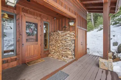 a pile of fire wood on the front of a cabin at Wulf's Lodge at Olympic Valley - Unwind in Hot Tub in Olympic Valley