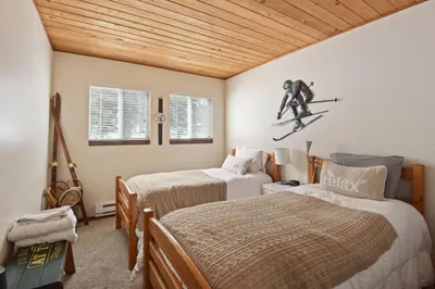 a bedroom with two beds and a skier in the air at Alpine Manor Retreat Mountain Relaxation in Alpine Meadows