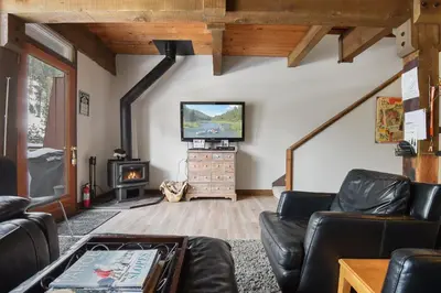 a living room with a couch and a tv at Alpine Manor Retreat Mountain Relaxation in Alpine Meadows