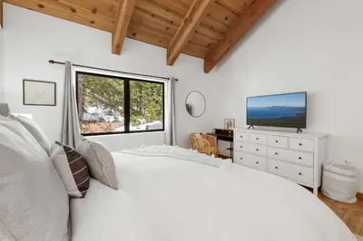 a white bedroom with a large bed and a window at Bright & Modern Cabin Luxury Home in Carnelian Bay in Carnelian Bay