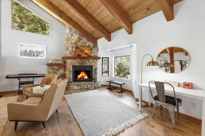 a living room with a fireplace and a table and chairs at Bright & Modern Cabin Luxury Home in Carnelian Bay in Carnelian Bay
