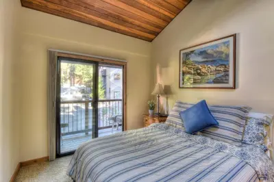 a bedroom with a bed and a sliding glass door at Brockway Springs Lodge Steps to Lake Access in Kings Beach