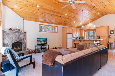 a living room with a large couch and a fireplace at Cedar Chateau with Game Room & HOA Access in Truckee