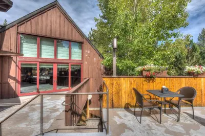 a patio with a table and chairs and a building at Granlibakken Retreat Near Tahoe Beach in Tahoe City