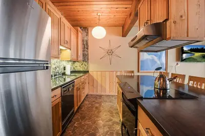 a kitchen with wooden cabinets and a stainless steel refrigerator at Comfy Alpine Meadows Endless fun in Alpine Meadows