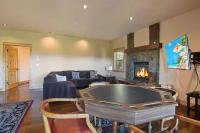 a living room with a table and a fireplace at Hilltop Hideaway w Game Room & Forest Views in Truckee