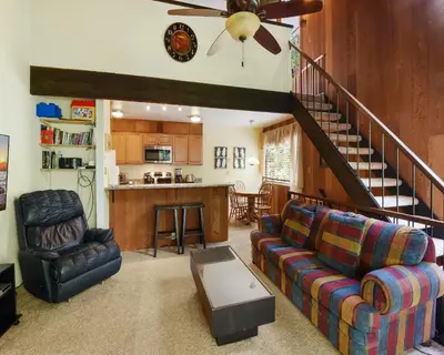 a living room with a couch and a staircase at Enjoy Forest Views Retreat at Kingswood Village in Kings Beach