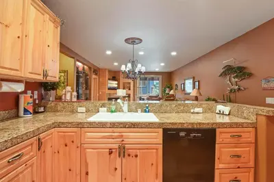 a kitchen with wooden cabinets and a sink at Crystal Charm Amazing 3 BDR Condo Close to Beaches Casinos & Skiing in Crystal Bay