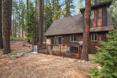 a small cabin in the woods with a wooden deck at Incline Cottage Year-Round Outdoor Fun in Incline Village