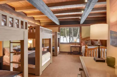 a bedroom with bunk beds and a desk with a desk at Joy on the River Stunning Waterfront Home for 10 in Olympic Valley