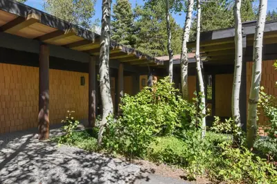 a yellow building with trees in front of it at Joy on the River Stunning Waterfront Home for 10 in Olympic Valley