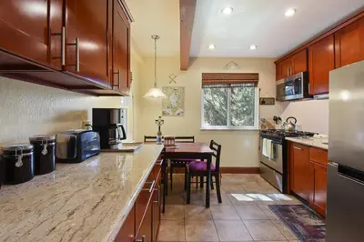 a kitchen with wooden cabinets and a table in it at Tahoe City Getaway Minutes from Lake and Activities in Tahoe City