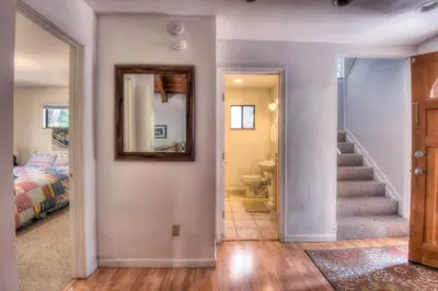a hallway with a mirror and a staircase in a house at Glacier Forest Getaway HOA Access in Truckee