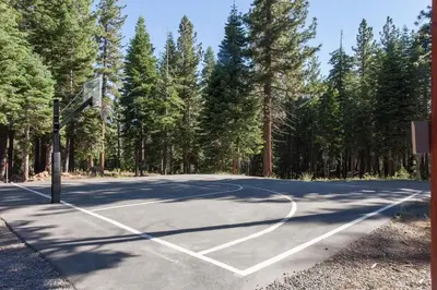 an empty basketball court with trees in the background at A Golden Getaway Pool Hot Tub Tennis & More in Truckee
