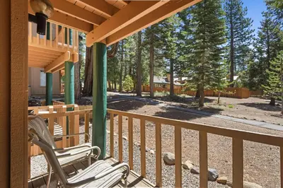 a deck with two chairs on a porch with trees at Kings Run Retreat Patio in Tahoe Vista