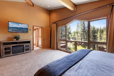 a bedroom with a bed and a large window at Kitzbuhel Paradise Sleeps 8 in Truckee