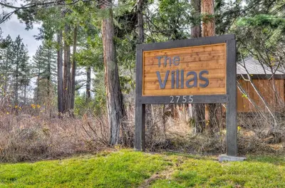 a sign for the villas in the woods at Lake Forest Villa Patio w BBQ in Tahoe City