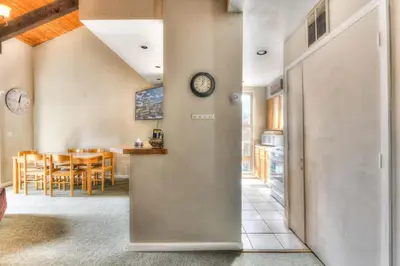 a kitchen and dining room with a clock on the wall at Lake Forest Villa Patio w BBQ in Tahoe City