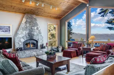 a living room with a large stone fireplace at Lakeview Hideaway 3BDR for 8 w Private Hot Tub in Carnelian Bay