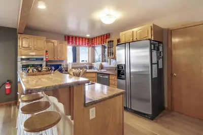 a kitchen with a stainless steel refrigerator and wooden cabinets at Lakeview Hideaway 3BDR for 8 w Private Hot Tub in Carnelian Bay