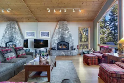 a living room with a stone fireplace in a house at Lakeview Hideaway 3BDR for 8 w Private Hot Tub in Carnelian Bay