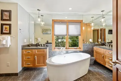 a large bathroom with a tub and a large mirror at Luxury Mountain Chalet Deck w BBQ & Lake Views in Tahoe City
