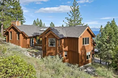a log home on a hill with trees at Luxury Mountain Chalet Deck w BBQ & Lake Views in Tahoe City