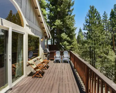 a deck with rocking chairs on a house at Lux Leisure Game Room & More in Truckee