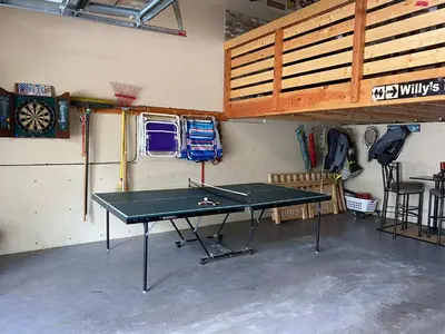 a ping pong table in a garage with a room at Lux Leisure Game Room & More in Truckee