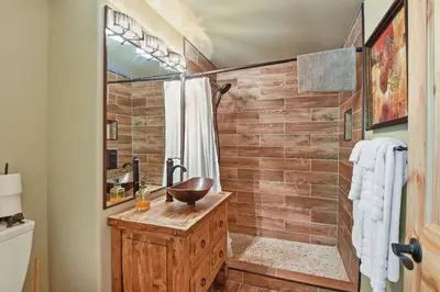 a bathroom with a sink and a shower with a wooden wall at Luxury Tahoe Chalet Minutes to Dining in Tahoe Vista