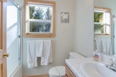 a bathroom with a sink and a toilet and a window at McKinney Estate w Roof Deck Beach & Hike in Tahoma
