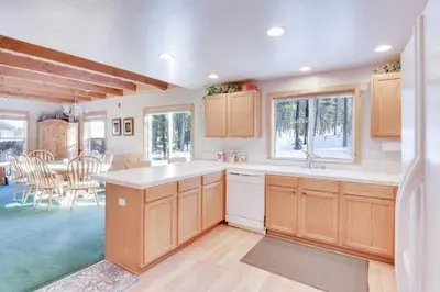 a kitchen with wooden cabinets and a dining room at McKinney Estate w Roof Deck Beach & Hike in Tahoma