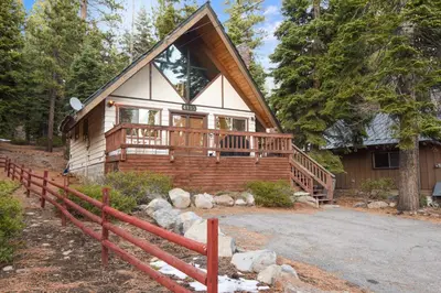 a log cabin with a porch and a fence at Moose Cabin Year Round Outdoor Fun w BBQ in Carnelian Bay