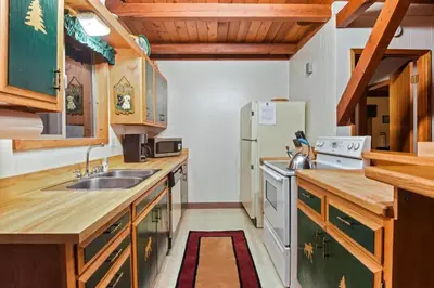 a kitchen with a sink and a refrigerator at Moose Cabin Year Round Outdoor Fun w BBQ in Carnelian Bay