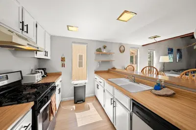 a kitchen with white cabinets and a wooden counter top at Mountain Shadows Chalet Tahoe Fun Awaits in Incline Village
