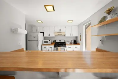 a kitchen with white cabinets and a wooden table at Mountain Shadows Chalet Tahoe Fun Awaits in Incline Village