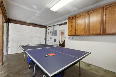 a ping pong table with a tennis racket on it at Hall Court Manor - Hot tub Pet Friendly Pool Table in Stateline