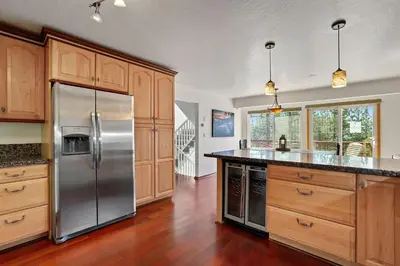 a kitchen with a stainless steel refrigerator and wooden cabinets at Hall Court Manor - Hot tub Pet Friendly Pool Table in Stateline