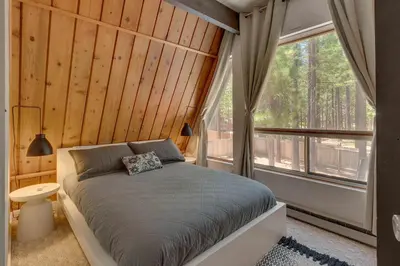 a bedroom with a bed and a large window at Heavenly Hollow in South Lake Tahoe