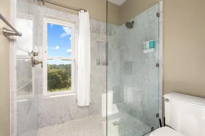 a bathroom with a shower and a toilet and a window at Yosemite Cloudline Ridge in Oakhurst