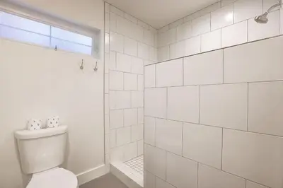 a white bathroom with a toilet and a shower at Amachen Cabin - Pet & Family Friendly - woof woof in South Lake Tahoe