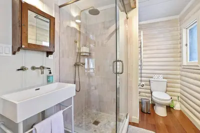 a bathroom with a shower and a sink and a toilet at Augies Authentic Log Cabin Pets Welcome in South Lake Tahoe