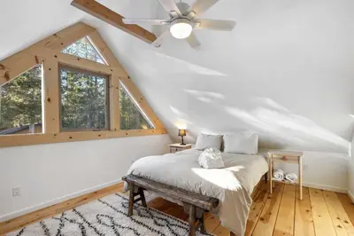 a bedroom with a bed and a ceiling fan at Augies Authentic Log Cabin Pets Welcome in South Lake Tahoe