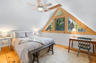 a bedroom with a bed and a desk and a window at Augies Authentic Log Cabin Pets Welcome in South Lake Tahoe
