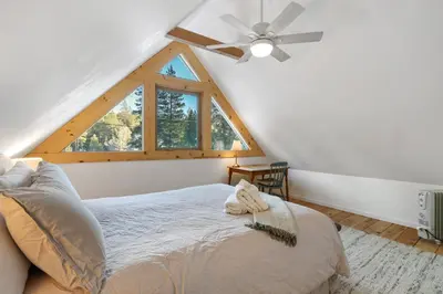 a bedroom with a bed and a ceiling fan at Augies Authentic Log Cabin Pets Welcome in South Lake Tahoe