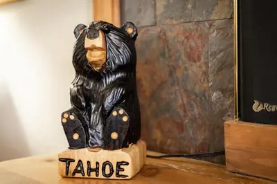 a black bear statue sitting on a wooden block at Bear Pause 4BR - Large Deck & Balcony in South Lake Tahoe